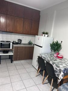 Δίπλα στον Μύλο Ξωτικών في تريكالا: مطبخ مع طاولة وثلاجة بيضاء