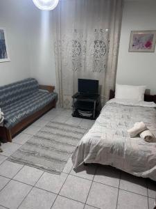 Δίπλα στον Μύλο Ξωτικών في تريكالا: غرفة نوم بها سرير وأريكة +صورة واحدة