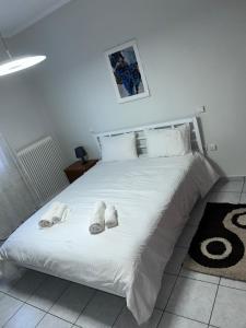 Δίπλα στον Μύλο Ξωτικών في تريكالا: غرفة نوم بسرير ابيض عليها حذاء ابيض