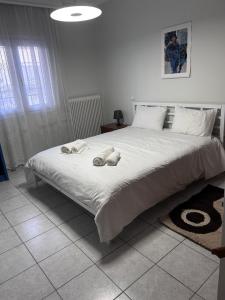 Δίπλα στον Μύλο Ξωτικών في تريكالا: غرفة نوم بها سرير كبير مع مناشف عليه