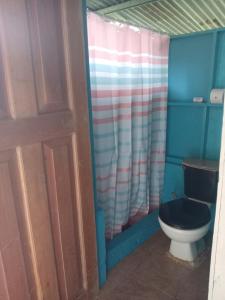 a bathroom with a toilet with a black seat at Ríos de agua Viva in Puerto Jiménez