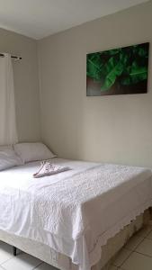 ein Schlafzimmer mit einem weißen Bett mit einem Bild an der Wand in der Unterkunft Apartamento no centro de Ananindeua in Ananindeua + 30 Fotos