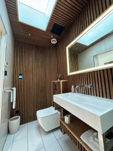 een badkamer met een wastafel, een toilet en een spiegel bij Contemporary 3-Bed Penthouse with River Views in Londen