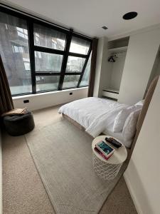 een slaapkamer met een bed en een tafel met een boek erop bij Contemporary 3-Bed Penthouse with River Views in Londen +8 foto's