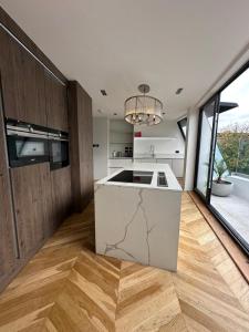 een keuken met een eiland in het midden van een kamer bij Contemporary 3-Bed Penthouse with River Views in Londen