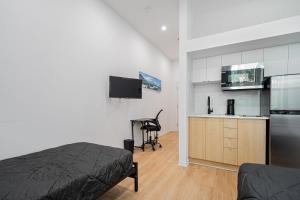 Il comprend une chambre avec un lit et une cuisine avec un bureau. dans l'établissement Loft Studio & 2 Single Beds For 2 Guests with Parking, à Montréal