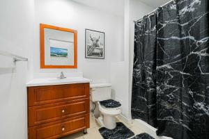 La salle de bains est pourvue d'un rideau de douche noir et de toilettes. dans l'établissement Loft Studio & 2 Single Beds For 2 Guests with Parking, à Montréal