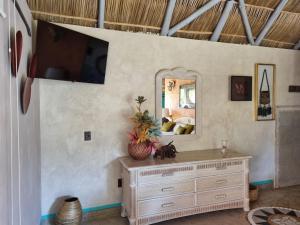 Pokój z komodą i lustrem na ścianie w obiekcie Eco Hotel Tahawi w mieście Ajijic