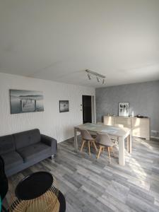 a living room with a table and a couch at LENS, Bel appartement lumineux spacieux en centre ville 3 chambres in Lens