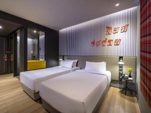 2 posti letto in una camera con un cartello sul muro di ibis Styles Bangkok Sukhumvit 4 a Bangkok Altre 49 foto