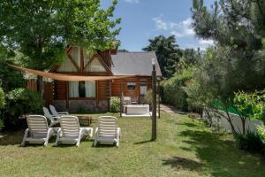 奥斯坦德Cabañas del Athuel的坐在房子前面的草上,一群椅子