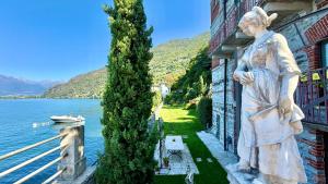 a statue of a woman standing next to a building at Villa Marina - Como lake in Bellano