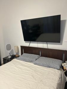 een grote flatscreen-tv boven een bed bij Cozy apartment in Punta Cana