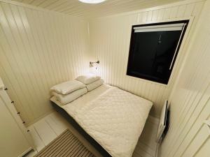 una piccola camera da letto con un letto con due cuscini di Charming Cottage Near Heatherhill With SPA - Rågeleje a Rågeleje