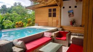 a swimming pool with a bench and chairs next to it at Citrus Creek Plantation in La Plaine
