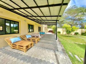 a patio with couches and tables under a pergola at Budget apartments near American embassy in Lusaka