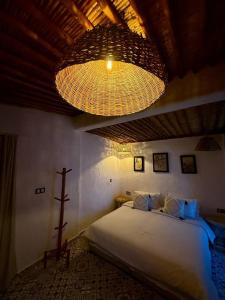 Walili Room - Comfort Oasis at Ferme Tynass : غرفة نوم بها سرير كبير وثريا