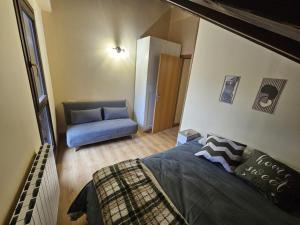 a bedroom with a bed and a blue couch at El Rincón de Escarrilla in Escarrilla
