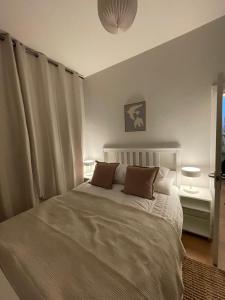 a bedroom with a white bed with two pillows at Cosy Coastal getaway 2 bed flat in Largs in Largs