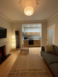 a living room with a couch and a bed at Cosy Coastal getaway 2 bed flat in Largs in Largs