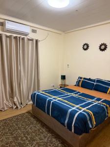 a bedroom with a large bed and a window at Budget apartments near American embassy in Lusaka