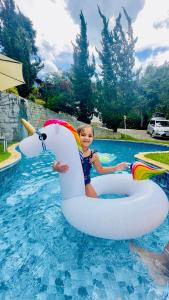 Ein junges Mädchen reitet auf einem aufblasbaren in der Unterkunft Pousada Casa Florinda in Posse