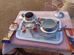 a tray with two tea pots and cups on a table at Luxor Adventure Guest House in Al Aqālitah