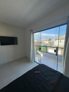 Un dormitorio con una cama y una ventana grande. en Casa 27, en Arraial do Cabo 22 fotos más