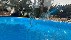 a pool with blue water pouring out of it at Pousada Cipó in Serra do Cipo