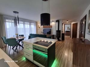 ein Wohnzimmer mit einer Küche und ein Wohnzimmer mit einem Tisch in der Unterkunft Swiąteczny Apartament Rotembark in Rotembark