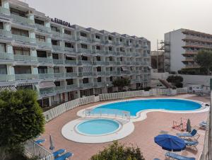 a large apartment building with a large swimming pool at Apartamento Studio Anau k&L- Playa del inglés - Yumbo in Playa del Ingles