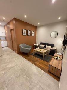 una sala de estar con un sofá y una mesa en Le Cosy Grange Blanche - 2 chambres, en Lyon