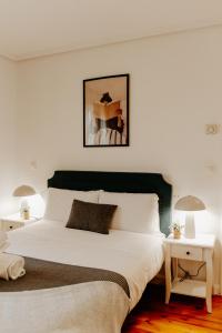 a bedroom with a large white bed with two tables at Casa Verde Logroño in Logroño