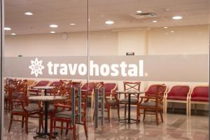 a restaurant with chairs and tables and a sign that reads travelghost at Travohostal Monterrey Historico in Monterrey
