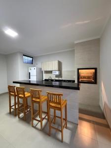 a kitchen with four chairs and a counter top at Recanto Neri & Neide in Olímpia