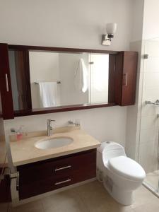 a bathroom with a sink and a toilet and a mirror at Apartamento amplio, moderno y muy bien ubicado in Duitama