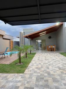 a house with a patio with a table and a dining room at Recanto Neri & Neide in Olímpia