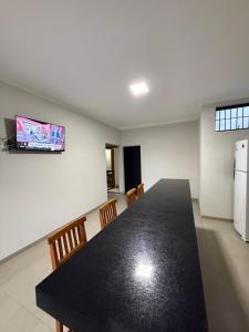 a dining room with a black table and chairs at Recanto Neri & Neide in Olímpia