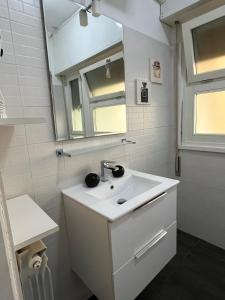 a white bathroom with a sink and a mirror at St Peter Lodge in Rome +33 photos