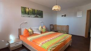 a bedroom with a bed with an orange comforter at Ferienwohnungen Zur Biberburg in Friedrichswalde