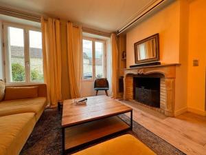Una sala de estar con un sofá y una chimenea. en Maison familiale climatisée, jardin cinema et jeux, en Épisy
