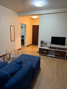 a living room with a blue couch and a flat screen tv at Budget apartments near American embassy in Lusaka