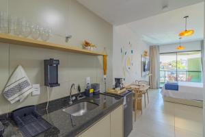 uma cozinha com pia e uma sala de estar em Nossa Praia Flats - Açores 109 Piscina Vista Panorâmica em Tamandaré