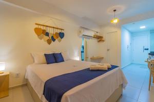 um quarto com uma cama grande com travesseiros azuis em Nossa Praia Flats - Açores 109 Piscina Vista Panorâmica em Tamandaré