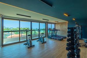 um ginásio com máquinas de cardio e uma grande janela em Nossa Praia Flats - Açores 109 Piscina Vista Panorâmica em Tamandaré