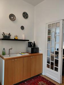 a kitchen with a sink and a microwave on the wall at Logies De Lelie in Antwerp