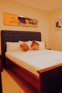 a bedroom with a large bed with orange pillows at Sasselo Hotel in Accra