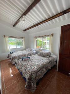 a bedroom with two beds and two windows at Villa Solara - A Beachfront Residence in San Clemente
