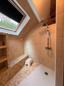 Un baño con ducha con ventana y lavabo. en Maison familiale climatisée, jardin cinema et jeux, en Épisy