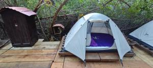 Commodity Camping Corazon Mazunte - Sol في مازونتي: خيمة على سطح خشبي مع درج خشبي